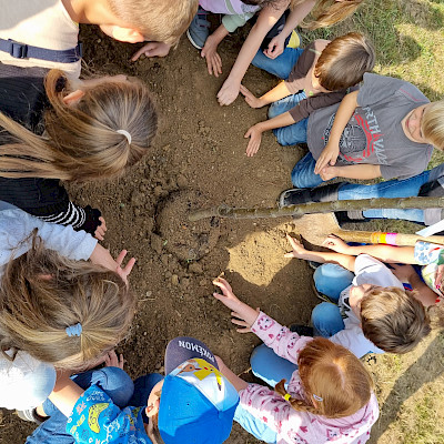 Kinder pflanzen eine alte Apfelbaumsorte 